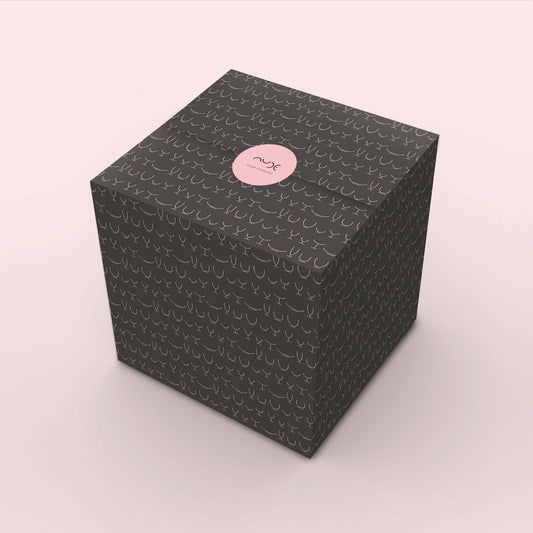 NUDE gift wrapping example, black wrapping paper with the icons of glassware in pink. Finished with a pink NUDE sticker